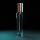 Clear perfume bottle gold cap on black blue background