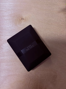 Black rectangular product with 'VYXN' branding on a wooden surface