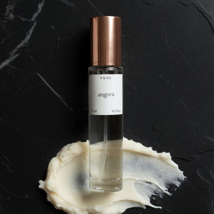 angora bottle on top of vanilla frosting black background. 