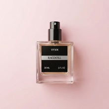 A 30 mL bottle of VYXN Ragdoll perfume with a black cap, placed on draped light pink satin fabric next to a round black stopper.