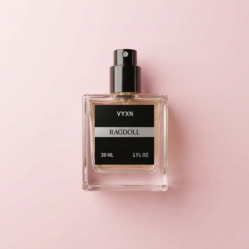 A 30 mL bottle of VYXN Ragdoll perfume with a black cap, placed on draped light pink satin fabric next to a round black stopper.